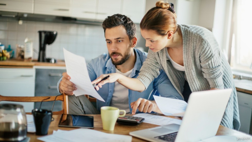 Un couple un peu stressé consultant des documents de finances personnelles.