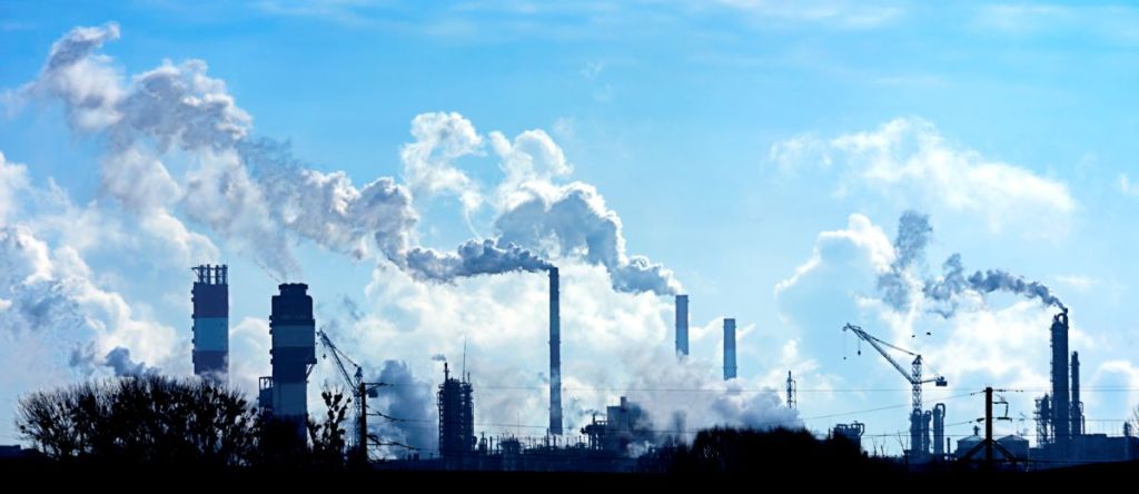 Des usines rejettent de la pollution et du CO2 dans l'atmosphère, aggravant le problème des changements climatiques.