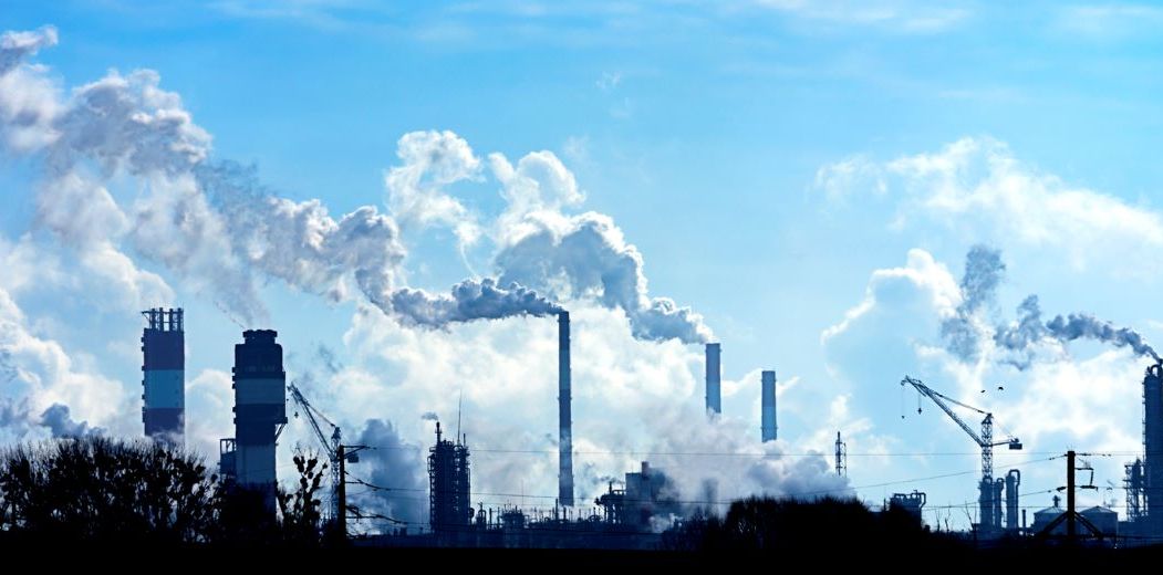 Des usines rejettent de la pollution et du CO2 dans l'atmosphère, aggravant le problème des changements climatiques.