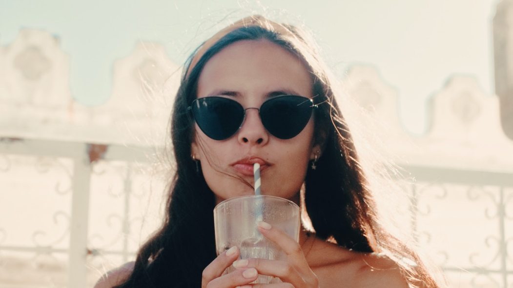 Une femme qui boit un cocktail en été