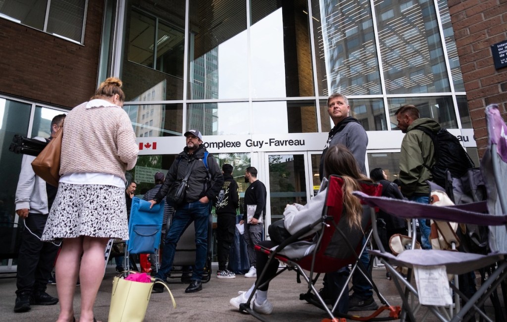 Une foule de citoyens dans une file d'attente pour obtenir un passeport devant le Complexe Guy-Favreau, à Montréal.