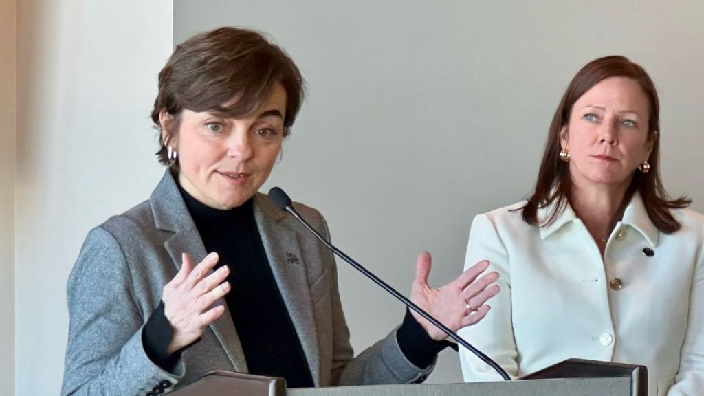 Christine Fréchette devant un lutrin.