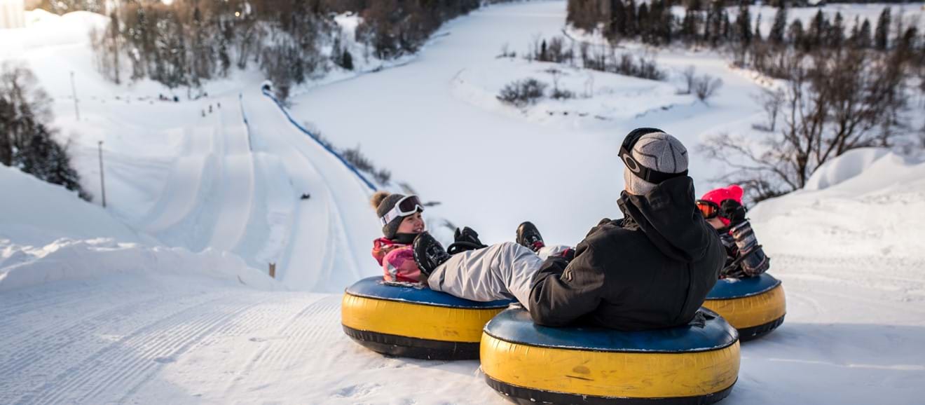 Une famille glisse sur des tubes au Centre de jeux d'hiver Valcartier.