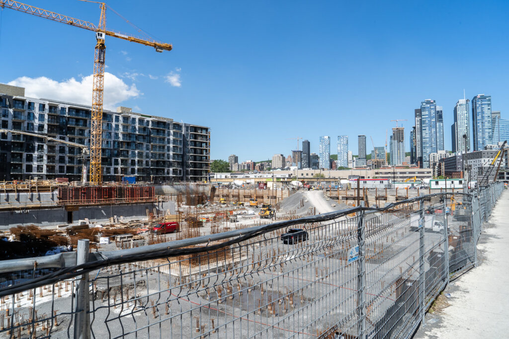Près d'un chantier de Griffintown, des grues sont visibles autour des grattes-ciel du centre-ville de Montréal.